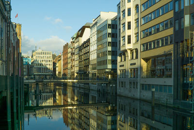 Buildings in city against cloudy sky