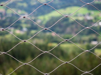 Wire mesh metal against landscape. close up