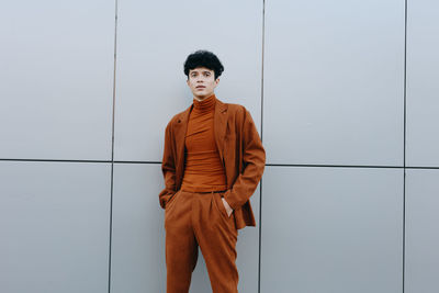 Rear view of man standing against wall