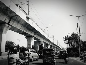 People on street against clear sky in city