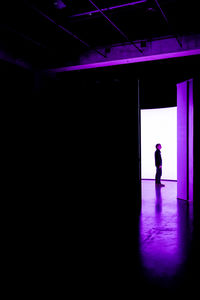 Silhouette person standing against illuminated building