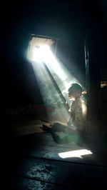 Man holding illuminated light in dark room