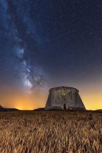 Built structure on field against sky at night