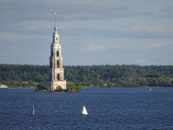 White building by sea against sky