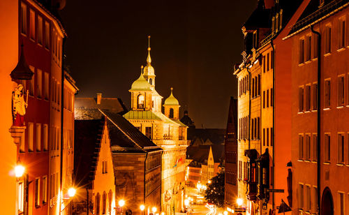 Low angle view of illuminated buildings against sky at night