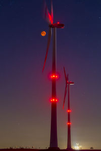 Wind wheels in front of blood moon at night