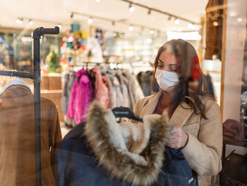 Woman choosing by rack in store