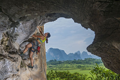 Young female climber climbing at remote area in yangshuo, china