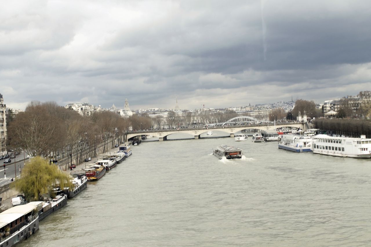 SCENIC VIEW OF RIVER AMIDST BUILDINGS AGAINST SKY