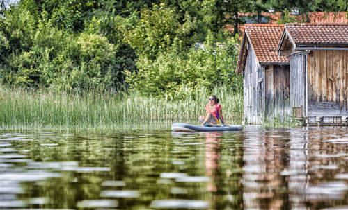 Woman relaxing on paddleboard in lake