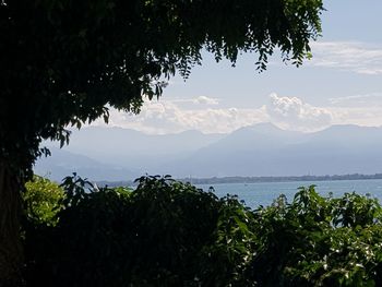 Scenic view of sea and mountains against sky