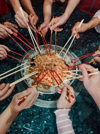 High angle view of people holding chopsticks in a gathering