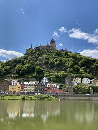Buildings by river against sky