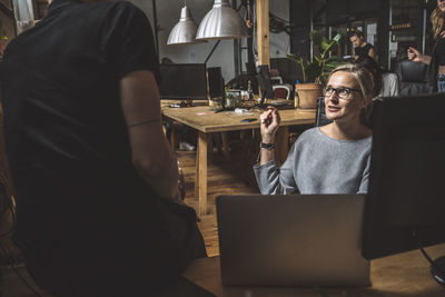 Midsection of woman using mobile phone while sitting on table