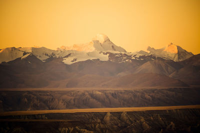 Scenic view of snowcapped mountains against sky during sunset