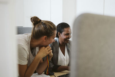 Smiling women talking in office