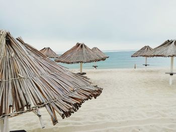 Panoramic view of lounge chairs on beach against sky