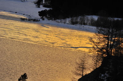 High angle view of snow covered land during sunset