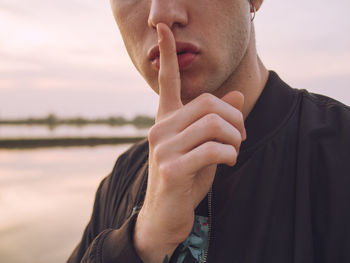 Close-up of man gesturing silence