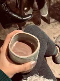 High angle view of hand holding coffee cup