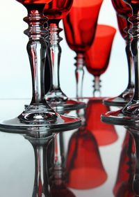 Close-up of red wine glasses with reflection on table
