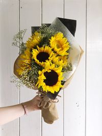 Close-up of hand holding yellow flower