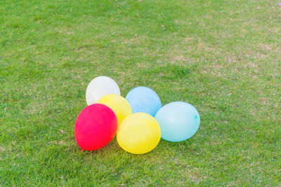 High angle view of multi colored balloons on field