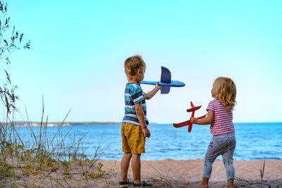 Caucasian little children holding toy planes in hands