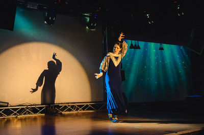 Full length of man standing on illuminated stage