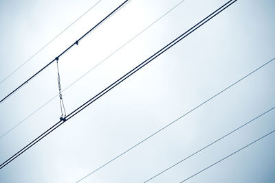 Low angle view of power lines against clear sky