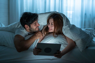 Young man using laptop on bed
