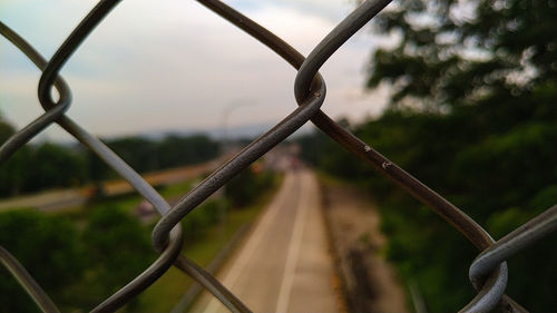 Close-up of chainlink fence against sky