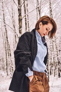 Beautiful young woman standing in forest