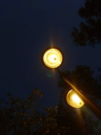 Low angle view of illuminated light against sky at night