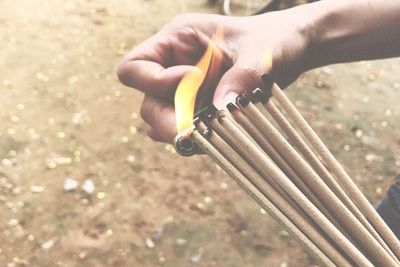 Close-up of hand lighting incenses