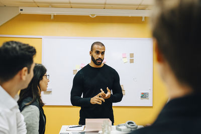 Businessman explaining strategy to colleagues in board room at office