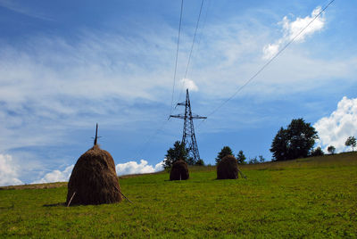 Electricity pylon on field against sky