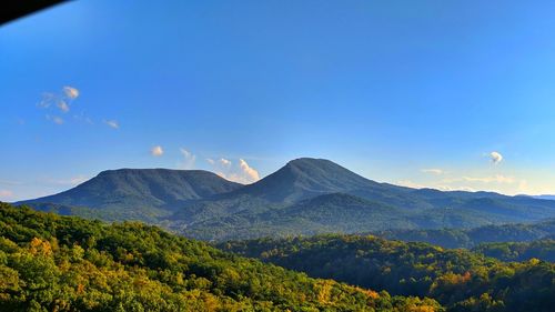 Scenic view of mountains against blue sky