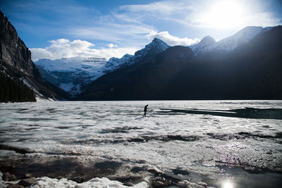 Scenic view of freeze lake water with snowcapped mountains against sky