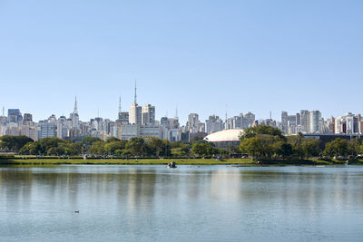 City at waterfront against clear sky