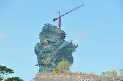 Low angle view of statue against clear blue sky