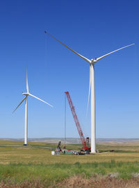 Windmill on field against clear sky