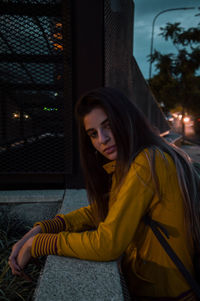 Portrait of young woman sitting outdoors