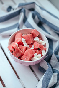 Delicious summer salad with slices of watermelon and feta cheese on a white bowl 