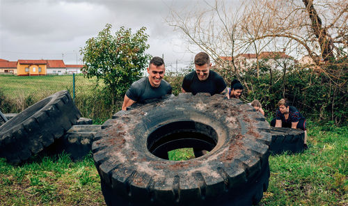 Strong men turning large tire on land