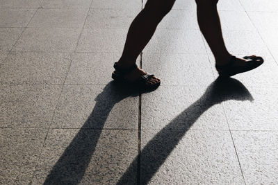 Low section of person standing on footpath