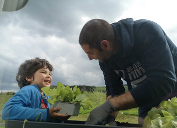 Father and son and daughter against sky