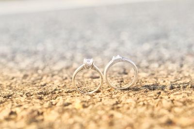 Close-up of wedding rings on sand
