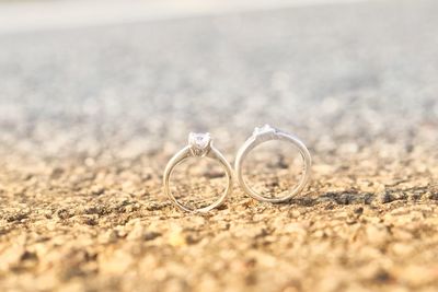 Close-up of wedding rings on sand