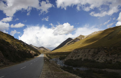 Panoramic view of road leading towards mountains against sky